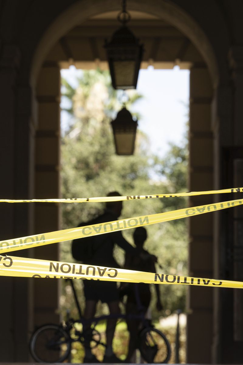 People walk past caution tape through Pasadena City Hall on Monday, Aug. 12, 2024, in Pasadena, Calif., after an earthquake was strongly felt from the Los Angeles area all the way to San Diego. (Sarah Reingewirtz/The Orange County Register via AP)