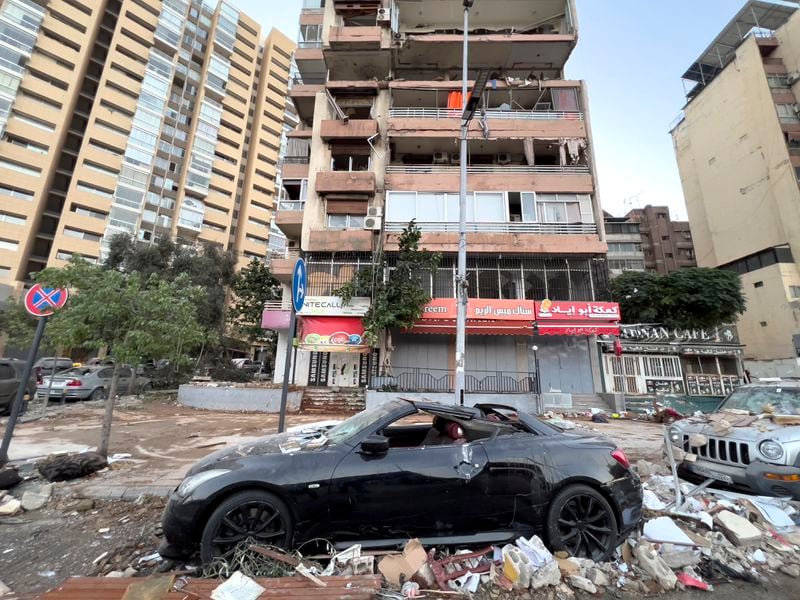 Damaged cars are parked in front of a building that was hit by an Israeli airstrike early Monday, Sept. 30, 2024. (AP Photo/Hussein Malla)