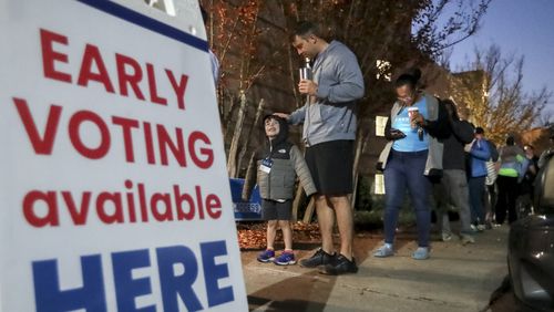 Josh Weeks waits in line with son, Noah, 4 as early voters hit the polls Friday, Nov. 4, 2022 at the Joan P. Garner Library in Atlanta. (John Spink / John.Spink@ajc.com)