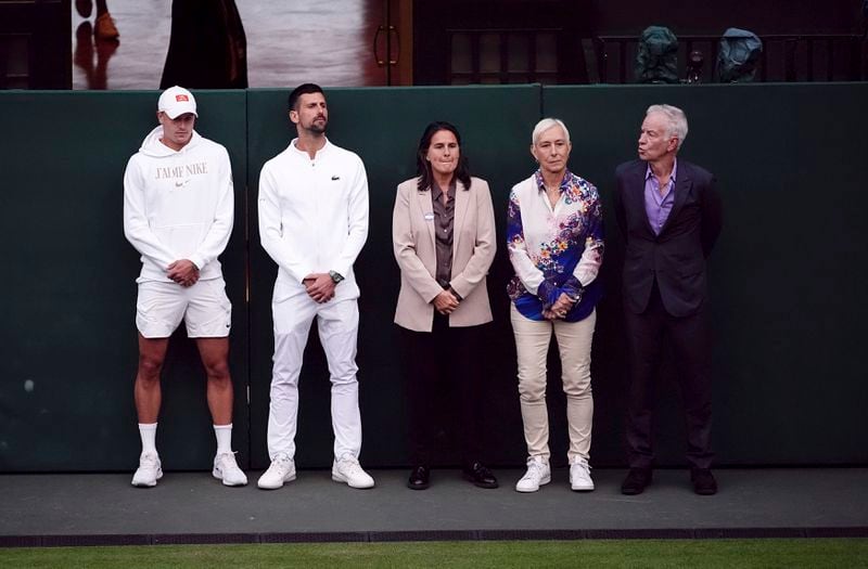 Current and former players, from left, Jack Draper, Novak Djokovic, Conchita Martinez, Martina Navratilova, and John McEnroe listen to Britain's Andy Murray as he speaks with Sue Barker following his first round doubles match with this brother Jamie against Australia's John Peers and Ricky Hijikata at the Wimbledon tennis championships in London, Thursday, July 4, 2024. (John Walton/PA via AP)