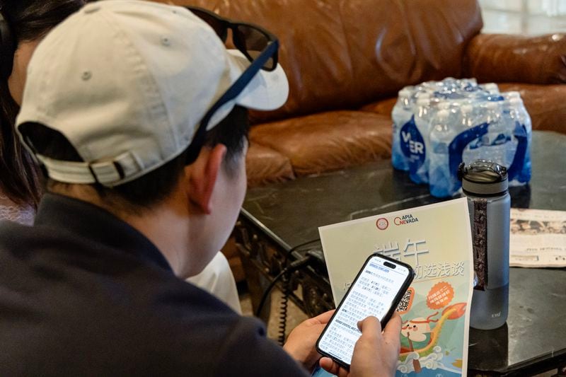 Eric Jeng, executive director of One APIA Nevada, reads information in Chinese about how to vote during the annual Dragon Boat Festival in Las Vegas on Wednesday, June 5, 2024. (Photo by Christopher Lomahquahu/News21)