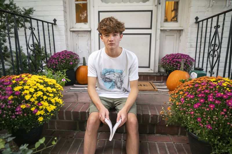 Chris Stanislawski, 14, poses for a portrait outside of his home in Garden City, N.Y., on Friday, Sept. 13, 2024. Chris didn't finish any books in his 8th grade English class, in part because their google classroom had detailed summaries of each chapter of every book. (AP Photo/Brittainy Newman)