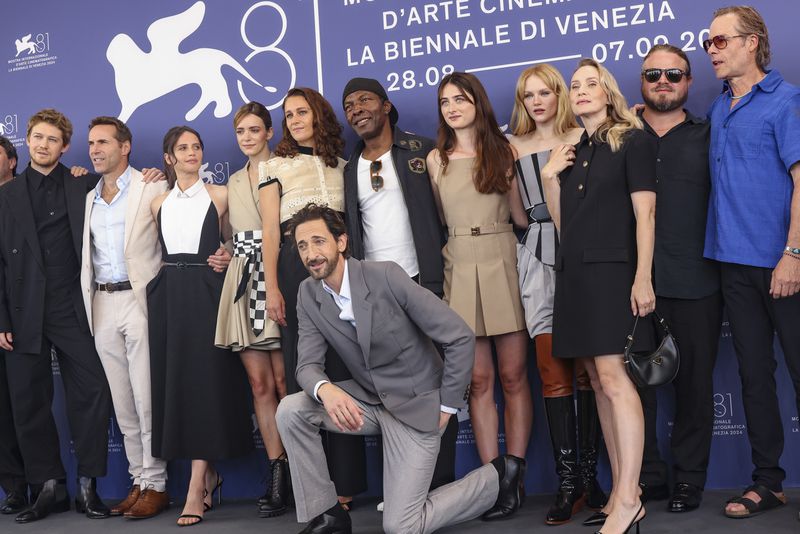 Joe Alwyn, from left, Alessandro Nivola, Felicity Jones, Stacy Martin, Ariane Labed, Adrien Brody, Isaach de Bankole, Raffey Cassidy, Emma Laird, writer Mona Fastvold, director Brady Corbet and Guy Pearce pose for photographers at the photo call for the film 'The Brutalist' during the 81st edition of the Venice Film Festival in Venice, Italy, on Sunday, Sept. 1, 2024. (Photo by Vianney Le Caer/Invision/AP)