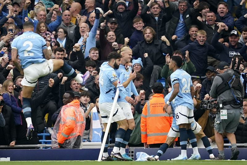 Manchester City's Erling Haaland, center, celebrates after scoring his side's opening goal during the English Premier League soccer match between Manchester City and Arsenal at the Etihad stadium in Manchester, England, Sunday, Sept. 22, 2024. (AP Photo/Dave Thompson)