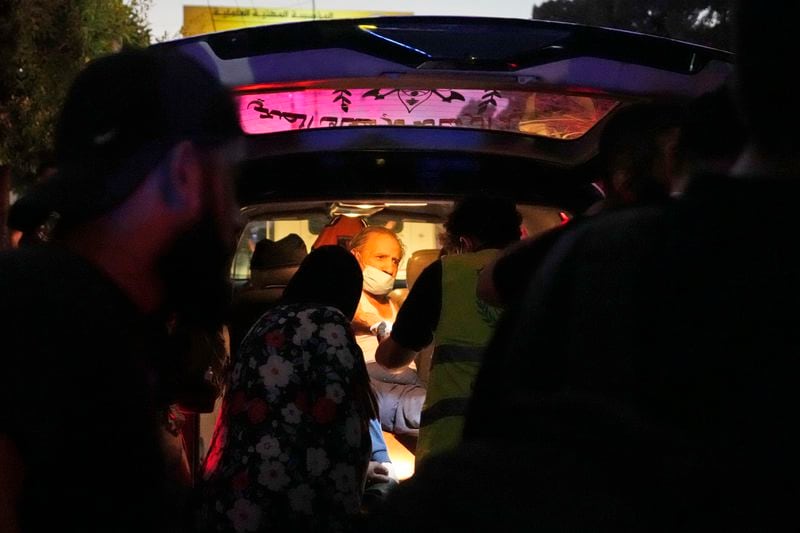 A wounded man sits in an ambulance at the site of an Israeli airstrike in Beirut's southern suburbs, Friday, Sept. 27, 2024. (AP Photo/Hassan Ammar)