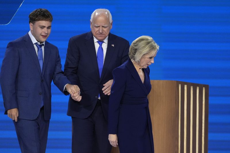 Democratic vice presidential nominee Minnesota Gov. Tim Walz, center, walks off stage with his wife Gwen Walz, right, and son Gus Walz after speaking during the Democratic National Convention Wednesday, Aug. 21, 2024, in Chicago. (AP Photo/J. Scott Applewhite)