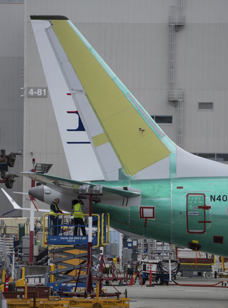 Workers check out the tail section of a Boeing 737 MAX airliner at the company's factory on Thursday, Sept. 12, 2024, in Renton, Wash. (AP Photo/Stephen Brashear)