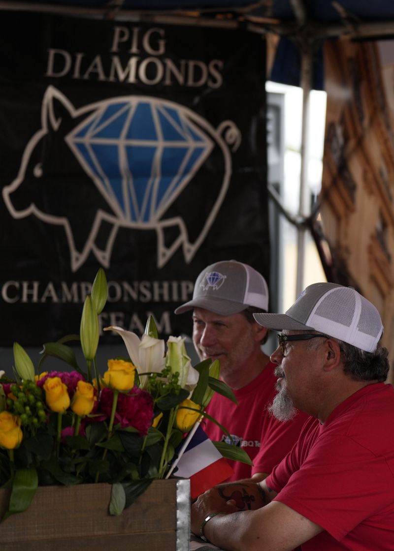 Bruno Panhoca, right, and Greg McManik, right, of the Pig Diamonds BBQ Team present their whole hog entry to judges at the World Championship Barbecue Cooking Contest, Saturday, May 18, 2024, in Memphis, Tenn. The team is comprised of members from Brazil and the United States. (AP Photo/George Walker IV)