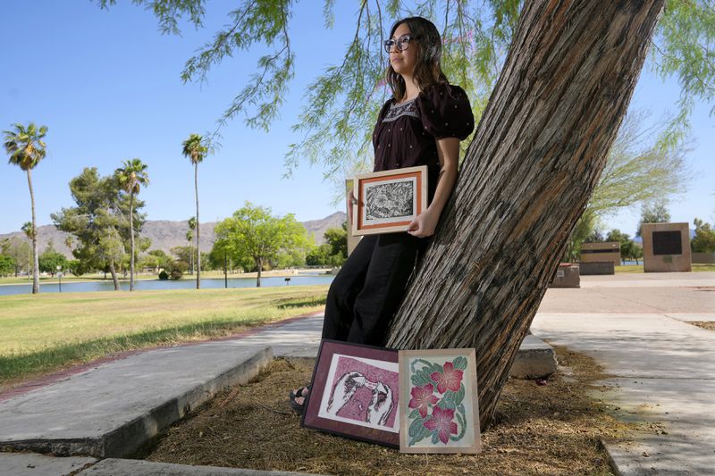 Olivia Yuen, 29, a middle school art teacher and well-known artist in Phoenix, who has a Chinese father and a Mexican mother, displays her linocut block prints Tuesday, May 21, 2024, in Laveen, Ariz. (AP Photo/Ross D. Franklin)