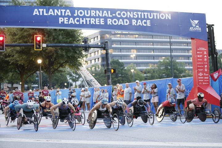 Women’s wheelchair racers take off at the start of the 55th running of the Atlanta Journal-Constitution Peachtree Road Race in Atlanta on Thursday, July 4, 2024.   (Miguel Martinez / Miguel Martinez / AJC)