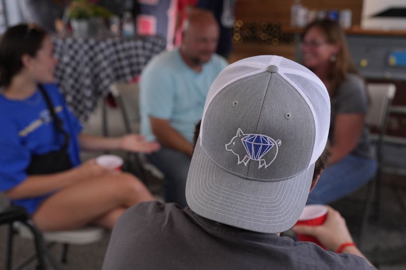 A member of the Pig Diamonds wears the team's logo on a hat at the World Championship Barbecue Cooking Contest, Friday, May 17, 2024, in Memphis, Tenn. Members of the cooking team are from Brazil and the United States. (AP Photo/George Walker IV)