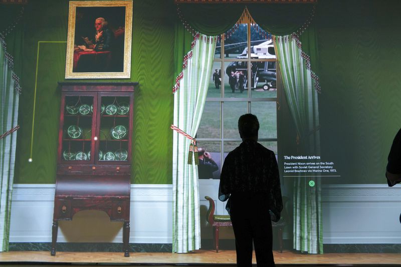 Members of the media tour an interactive 3D room of the White House Green Room as is today, shown at The People's House exhibit, Monday, Sept. 16, 2024 in Washington. (AP Photo/Jose Luis Magana)