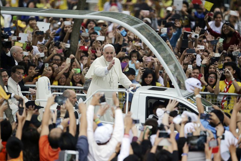 FILE - Crowds cheer as Pope Francis passes by during his meeting with the youth at the University of Santo Tomas in Manila, Philippines, on Jan. 18, 2015. (AP Photo/Aaron Favila, File)