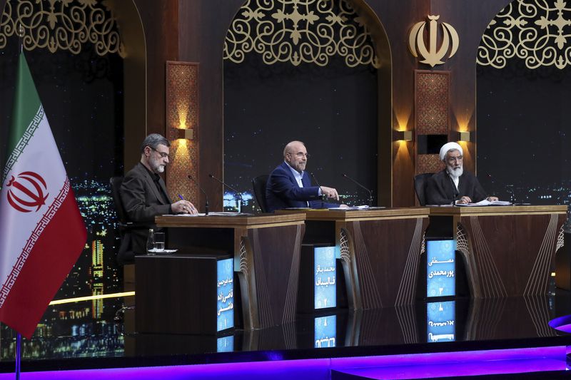 In this photo released by Iranian state-run TV, IRIB, Iran's Parliament Speaker Mohammad Bagher Qalibaf, a presidential candidate for the June 28 election, center, speaks as other candidates Mostafa Pourmohammadi, a former Minister of Justice, right, and Amirhossein Ghazizadeh Hashemi, Vice President of late Ebrahim Raisi, listen in a debate of the candidates at the TV studio in Tehran, Iran, Thursday, June 20, 2024. (Morteza Fakhri Nezhad/IRIB via AP)