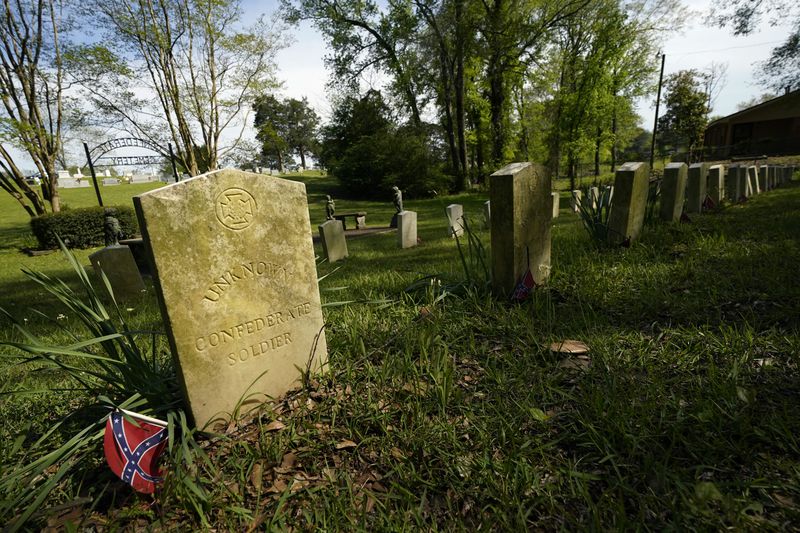 The sun sets on the grave markers in the Confederate cemetery in Grenada, Miss., April 12, 2023. (AP Photo/Rogelio V. Solis)