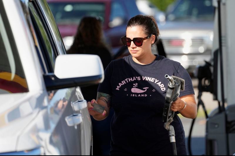 A woman fuels her car at the gateway to Cape Cod in Sagamore, Mass., Friday, Aug. 30, 2024. (AP Photo/Michael Dwyer)