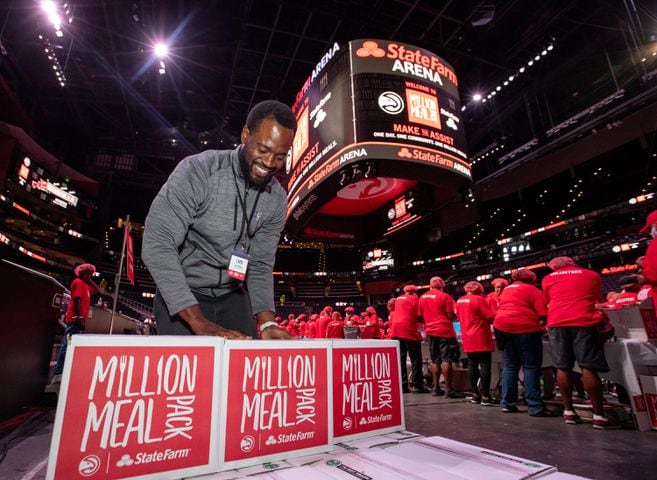 Chris Gilchrist, with US Hunger, puts boxes of red lentil jambalaya meal kits on pallets for local food banks.  (Jenni Girtman for The Atlanta Journal-Constitution)