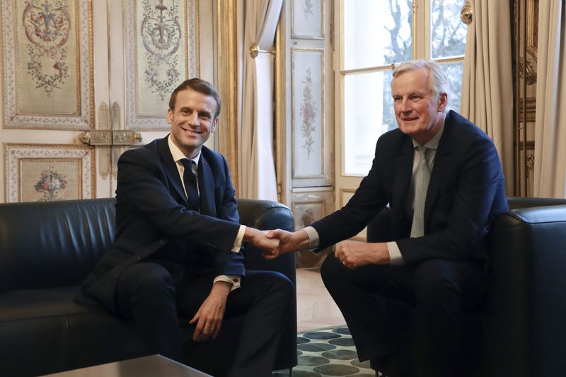 FILE - French President Emmanuel Macron, left, shakes hands with then-European Union chief Brexit negotiator Michel Barnier at the Elysee Palace in Paris, Friday, Jan. 31, 2020. (Ludovic Marin/Pool Photo via AP, File)