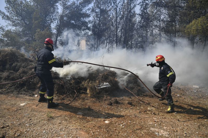 Firefighters operate in Dioni, northeast of Athens, Greece, Monday, Aug. 12, 2024. Hundreds of firefighters backed by dozens of water-dropping planes and helicopters were battling the flames from first light Monday, with a major forest fire that began the previous day raging out of control on the fringes of Athens, fanned by strong winds. (AP Photo/Michael Varaklas)