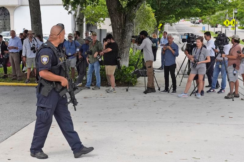 A Department of Homeland Security officer, left, prepares to block traffic for a prisoner transport van at the Paul G. Rogers Federal Building and U.S. Courthouse, where a man suspected in an apparent assassination attempt targeting former President Donald Trump, was charged with federal gun crimes, Monday, Sept. 16, 2024, in West Palm Beach, Fla. (AP Photo/Wilfredo Lee)