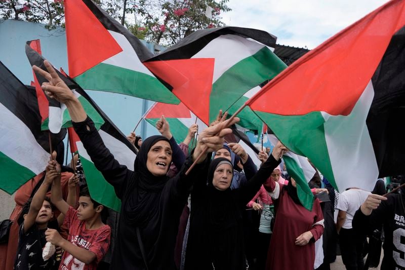 Palestinians in Lebanon wave their national flags during a protest in front of the United Nations Relief and Works Agency (UNRWA) headquarters in Beirut, Lebanon, Tuesday, Sept. 17, 2024. (AP Photo/Bilal Hussein)