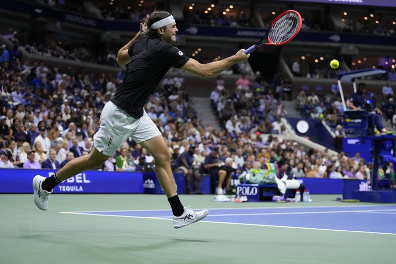 Taylor Fritz, of the United States, returns a shot to Frances Tiafoe, of the United States, during the men's singles semifinals of the U.S. Open tennis championships, Friday, Sept. 6, 2024, in New York. (AP Photo/Kirsty Wigglesworth)