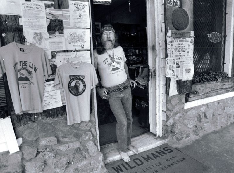 Dent 'Wildman' Myers, in 1990 at his Civil War relic shop in Kennesaw. An ordinance passed by the Kennesaw city council requiring each home to have at least one gun with ammo attracted national attention, and media were attracted to Myers' flamboyant appearance and his outspoken support for the regulation. He typically wore a brace of .45-caliber pistols while in the shop,. Calvin Cruce/AJC staff) 1979