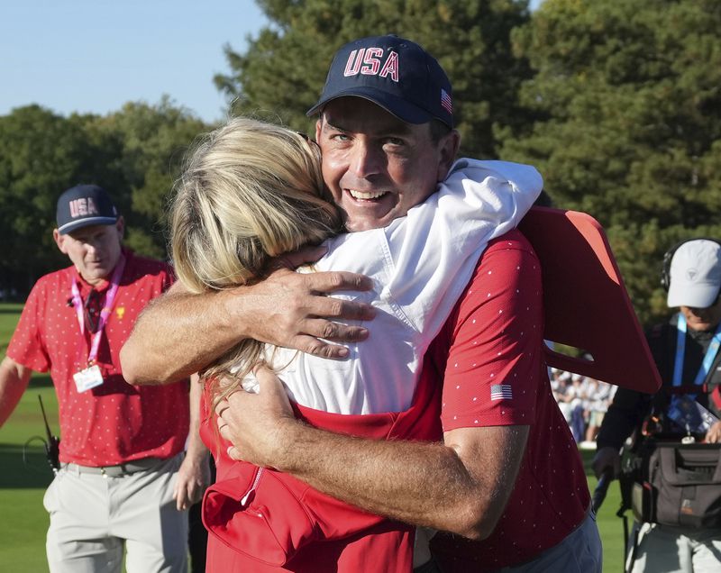 United States team member Keegan Bradley, right, hugs his wife Jillian Stacey after winning the Presidents Cup golf tournament at Royal Montreal Golf Club, Sunday, Sept. 29, 2024, in Montreal. (Nathan Denette/The Canadian Press via AP)