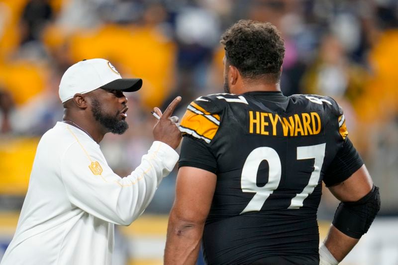 Pittsburgh Steelers head coach Mike Tomlin, left, talks to defensive tackle Cameron Heyward (97) prior to an NFL football game against the Dallas Cowboys, Sunday, Oct. 6, 2024, in Pittsburgh. (AP Photo/Gene J. Puskar)