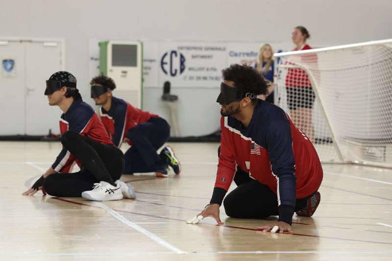 U.S. goalball athletes Zion Walker, right, Tyler Merren, left, and Tre'Shaun Faison train their defensive formation at a goalball practice during a media tour at the U.S. team High Performance Center during the Paralympic Games in Paris on Wednesday, Aug. 28, 2024. (AP Photo/Avni Trivedi)