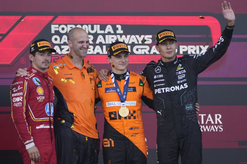 From the left, second-placed Ferrari driver Charles Leclerc of Monaco, McLaren's chief engineer Tom Stallard, first-placed McLaren driver Oscar Piastri of Australia, and third-placed Mercedes driver George Russell of Britain stand at the podium after the Formula One Grand Prix in Baku, Azerbaijan, on Sunday, Sept. 15, 2024. (AP Photo/Sergei Grits)