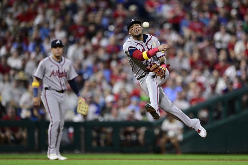 Atlanta Braves' Orlando Arcia throws to first for an out on a ball hit by Philadelphia Phillies' J.T. Realmuto during the fifth inning of a baseball game, Sunday, Sept. 1, 2024, in Philadelphia. (AP Photo/Derik Hamilton)