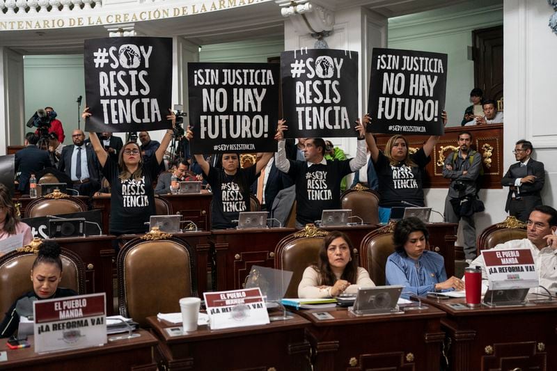 Legislators protest judicial reform in the Mexico City Congress, Thursday, Sept. 12, 2024. The signs read in Spanish "I am resistance, " and "Without justice there's no future." (AP Photo/Felix Marquez)