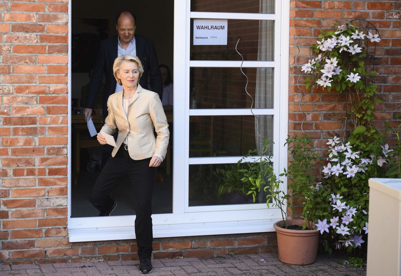 Ursula von der Leyen, left, President of the European Commission, walks to a ballot box outside a polling station in the Hanover region with her husband Heiko to cast her vote in the European Parliament elections, in Burgdorf, Germany on Sunday, June 9, 2024. (Julian Stratenschulte/dpa via AP)