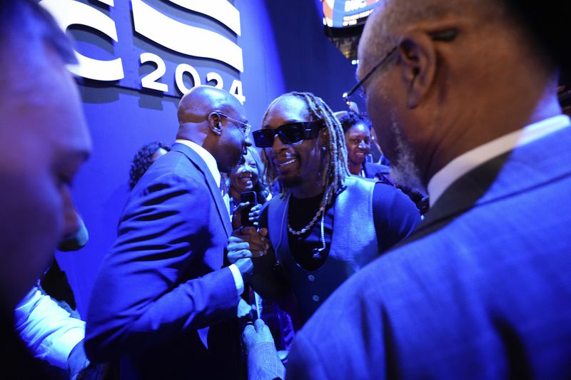 Lil Jon shakes hand with Sen. Raphael G. Warnock, D-Ga., left, as he join Georgia delegation during the Democratic National Convention Tuesday, Aug. 20, 2024, in Chicago. (AP Photo/Paul Sancya)