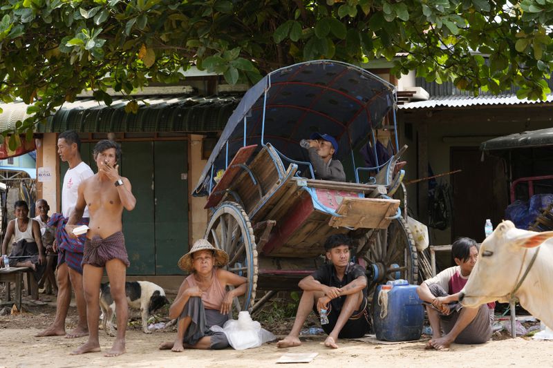 Local residents rest near a flooded road in Naypyitaw, Myanmar, Saturday, Sept. 14, 2024. (AP Photo/Aung Shine Oo)