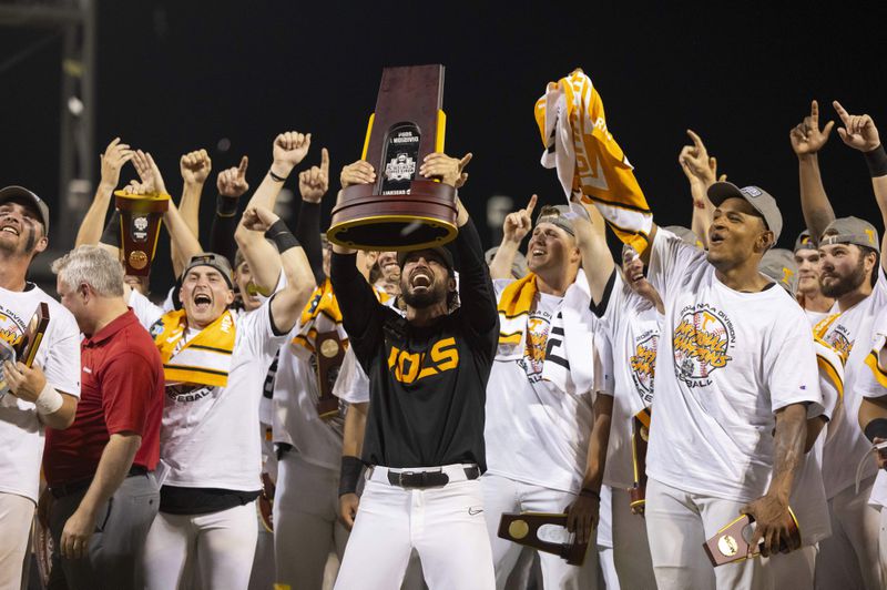 Tennessee coach Tony Vitello, center, hoists the championship trophy following his team's 6-5 victory against Texas A&M in Game 3 of the NCAA College World Series baseball finals in Omaha, Neb., Monday, June 24, 2024. (AP Photo/Rebecca S. Gratz)