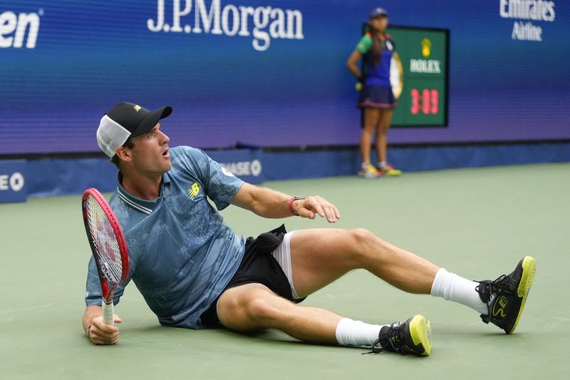 Tommy Paul, of the United States, falls to the court after returning a shot to Gabriel Diallo, of Canada, during the third round of the U.S. Open tennis championships, Saturday, Aug. 31, 2024, in New York. (AP Photo/Kirsty Wigglesworth)