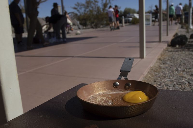 An egg lays in a small frying pan at the Furnace Creek Visitors Center in Death Valley National Park, Calif., Sunday, July 7, 2024. Forecasters say a heat wave could break previous records across the U.S., including in Death Valley. (AP Photo/Ty ONeil)