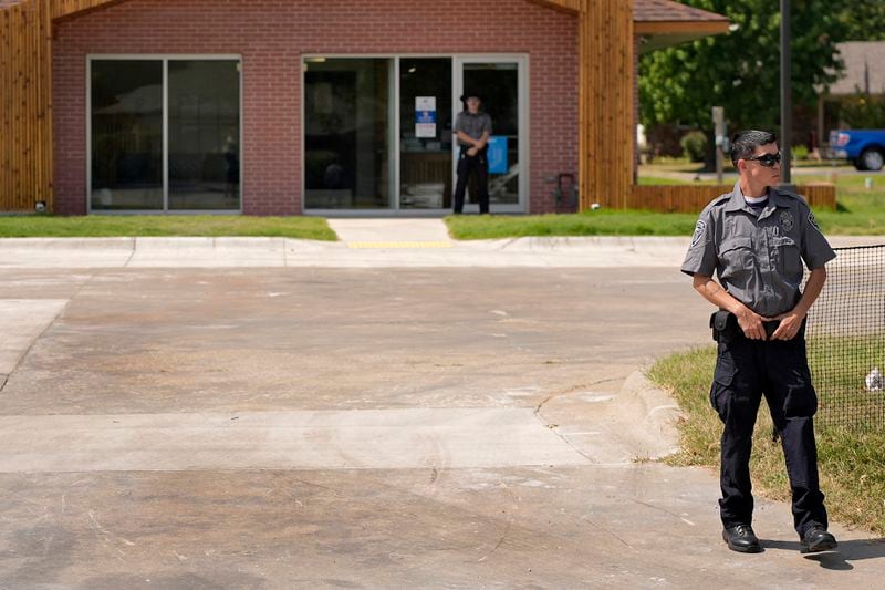 Security personnel stand outside a recently opened Planned Parenthood clinic, Tuesday, Sept. 10, 2024, in Pittsburg, Kan. (AP Photo/Charlie Riedel)