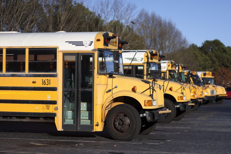 DeKalb County Schools buses are shown at the DeKalb County Schools Administrative and Instructional Complex, Monday, Feb. 13, 2023, in Stone Mountain. A new Georgia law increases the penalty for passing a stopped school bus to at least $1,000. (Jason Getz /AJC)
