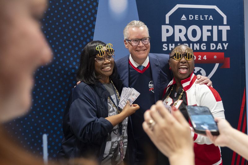 Carletta Cooper, left, and Deandjane Mitchell pose for a photograph with Delta CEO Ed Bastian during a profit sharing day celebration at the Atlanta Customer Engagement Center in Hapeville on Wednesday, Feb. 14, 2024. (Ben Gray / Ben@BenGray.com)