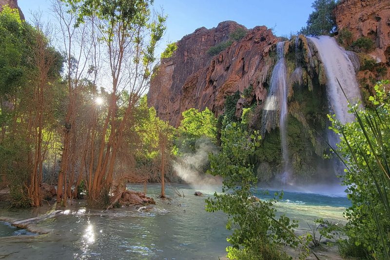 This photo provided by Randy Shannon shows Mooney Falls on the Havasupai reservation outside the village of Supai, Ariz., May 19, 2024. Dozens of tourists say they fell ill on a recent visit to a popular and picturesque stretch of waterfalls deep in a gorge neighboring Grand Canyon National Park. (Randy Shannon via AP)