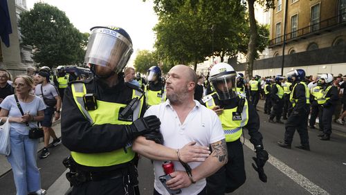A man is detained as people attend the 'Enough is Enough' protest in Whitehall, London, Wednesday July 31, 2024, following the fatal stabbing of three children at a Taylor Swift-themed holiday club on Monday in Southport. (Jordan Pettitt/PA via AP)
