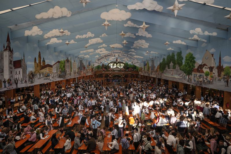 Visitors wait in the tent of the Hacker-Pschorr brewery the start of the 189th 'Oktoberfest' beer festival in Munich, Germany, Saturday, Sept. 21, 2024. (AP Photo/Matthias Schrader)