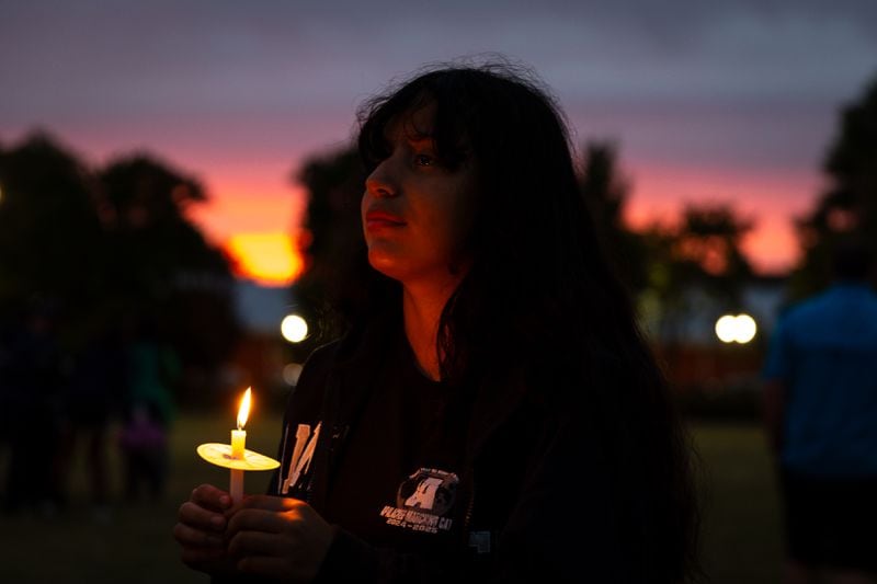 Apalachee High School student Kimberly Martinez, 14, holds a candle during a Friday night vigil at Jug Tavern Park.