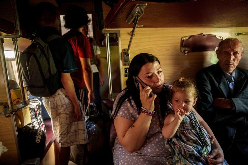 Family sits in evacuation train in Pokrovsk, Donetsk region, Ukraine, Monday, August 19, 2024. Due to the advance of Russian troops, the war affects more and more new settlements to the west of the Donetsk region. Intensive shelling forced people to leave homes. (AP Photo/Evgeniy Maloletka)