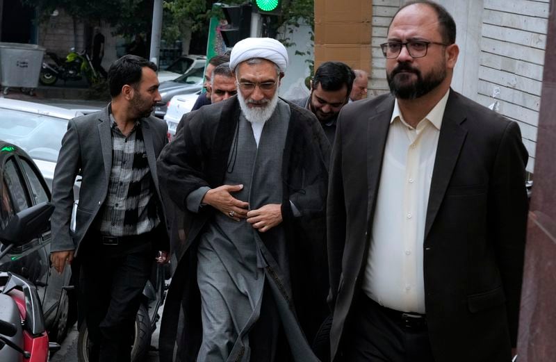 Candidate for June 28, Iran's presidential election Mostafa Pourmohammadi, center, a former Minister of Justice, arrives for his press conference in Tehran, Iran, Sunday, June 23, 2024. (AP Photo/Vahid Salemi)