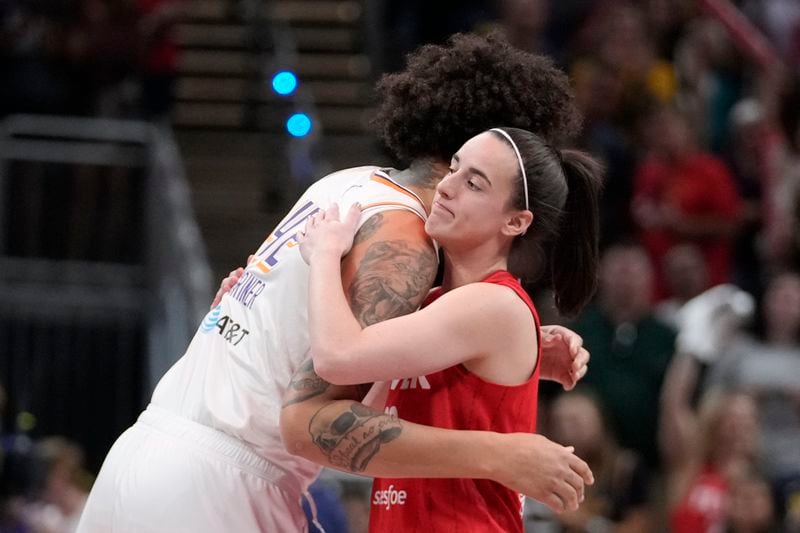 Indiana Fever guard Caitlin Clark, right, hugs Phoenix Mercury's Brittney Griner (42) before a WNBA basketball game, Friday, Aug. 16, 2024, in Indianapolis. (AP Photo/Darron Cummings)