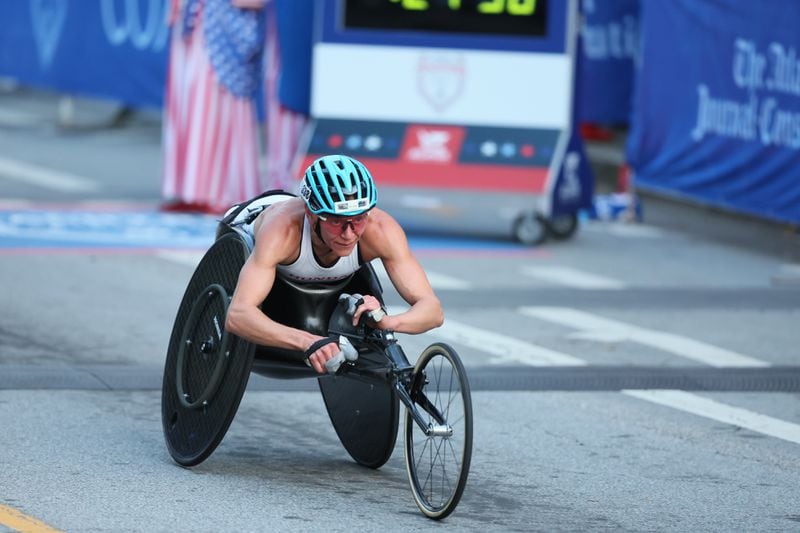 Susannah Scaroni crosses the finish line to win the female wheelchair division of the 55th running of the Atlanta Journal-Constitution Peachtree Road Race in Atlanta on Thursday, July 4, 2024.   (Jason Getz / AJC)